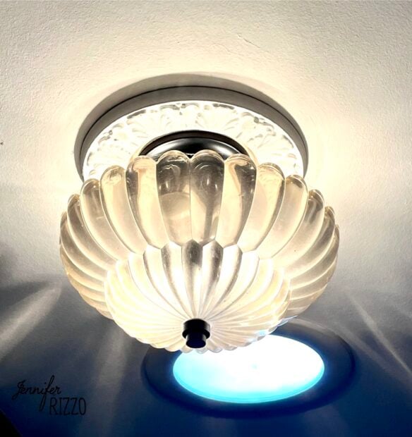 A decorative, frosted glass ceiling light fixture is mounted on a white ceiling, casting a soft glow.
