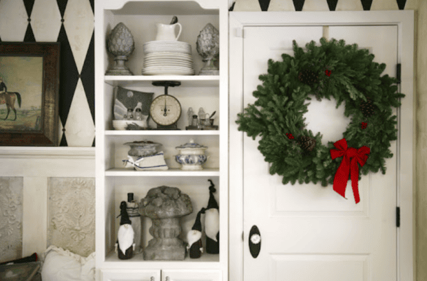 Kitchen seating with tall cabinet ith smaller items and wreath on door