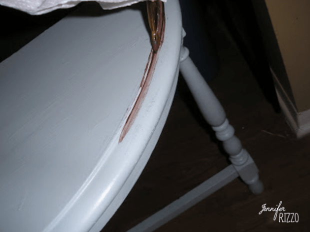 A close-up of a light blue wooden table, its large crack along the edge revealing the wood beneath—an authentic detail often found in aging furniture with glaze.