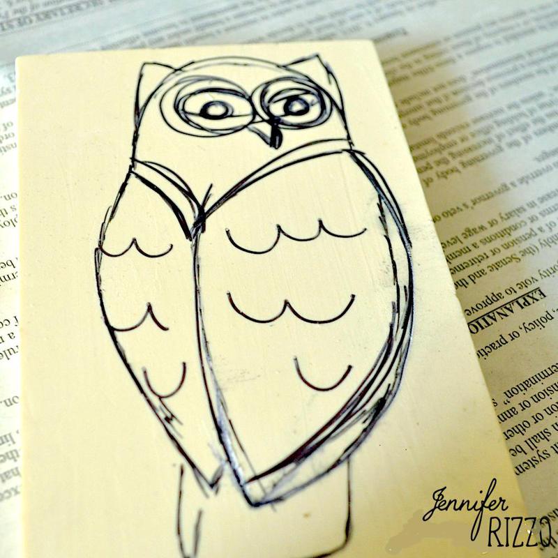 A simple black ink sketch of an owl on a cream-colored surface, placed atop a printed newspaper page—perfect inspiration if you want to carve your own rubber stamps.