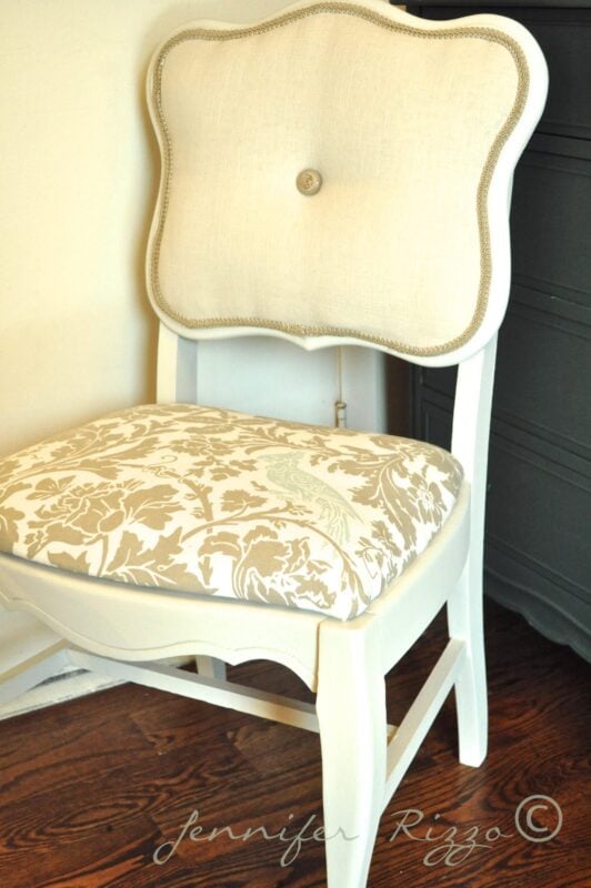 White wooden chair with a fabric-upholstered, tufted backrest and a floral-patterned cushioned seat, perfect for modernizing an old cane back chair with style, placed on a wooden floor.