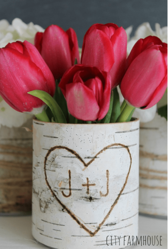 Red tulips arranged in a DIY birch bark vase with a heart and "J + J" carved on the front. The text "CITY FARMHOUSE" is visible in the bottom right corner.