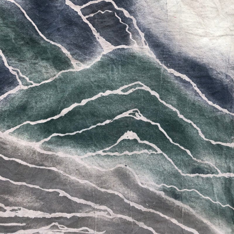 Abstract pattern with layered green, white, and gray wavy lines resembling geological strata or marble texture, achieved through a glue resist art technique.