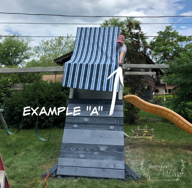 A person adjusts a new fabric canopy over a striped tarp and wooden ramp structure in the yard. Nearby, swings and a slide await beneath the cloudy sky, surrounded by trees. Text reads "Example 'A'.
