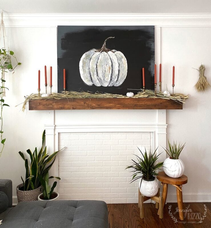 fall mantel with brass cnadles ticks and pumpkins