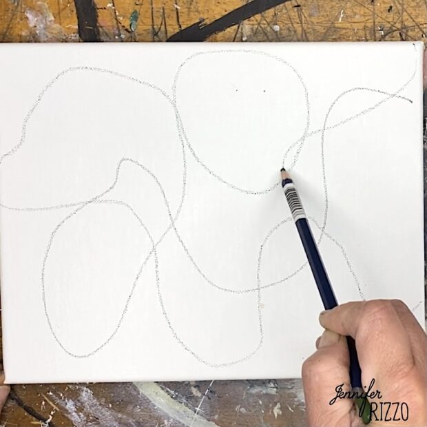 A hand holds a pencil, drawing abstract, overlapping curved shapes on a blank white canvas—creating easy line fill abstract art.