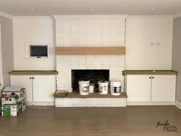 Fireplace painted white with built in cabinets on each side