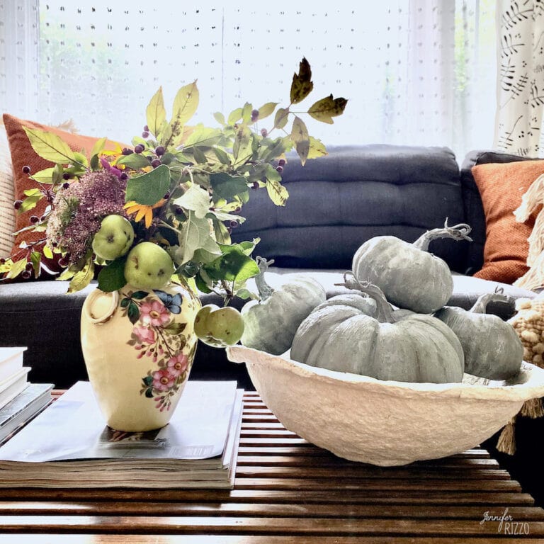Terra Cotta painted baking soda paint pumpkins with a vase of flowers and apples in a paper mache bowl