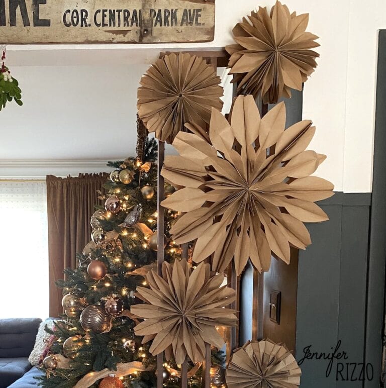 Different size paper bag snowflakes made from brown kraft bags on a wall