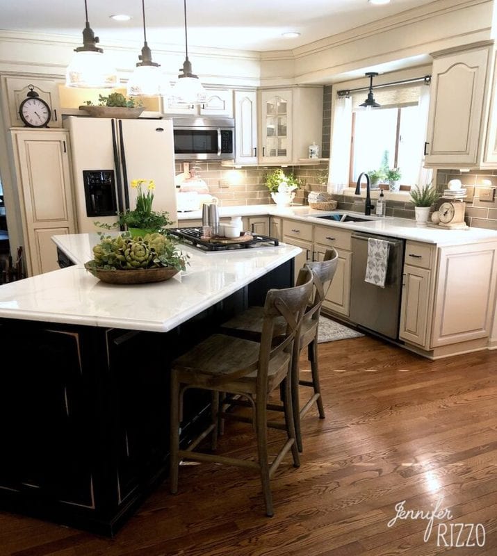 Benjamin Moore Chantilly Lace cabinets in a white kitchen with a black island and marble countertops