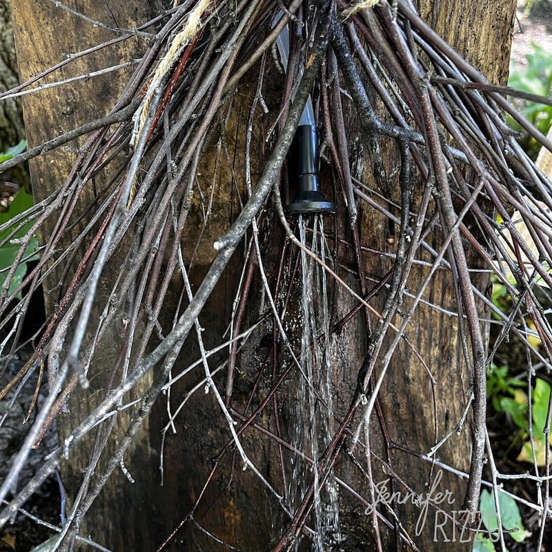 HIdden water fountain hose by bundled twigs