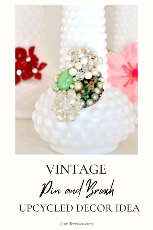 White hobnail vases upcycled with colorful vintage pins and brooches; text reads "Upcycle Milk Glass Vases with Broken Jewelry – Vintage Pin and Brooch Decor Idea.