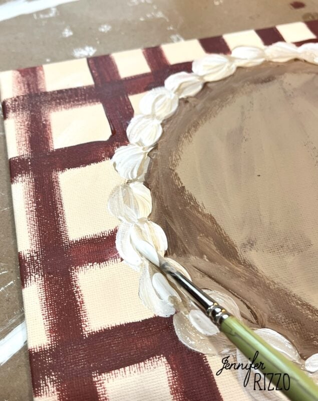 A paintbrush adds white decorative details to the edge of a brown and cream checkered Pumpkin Pie Wall Art canvas. The name "Jennifer Rizzo" is visible in the corner.