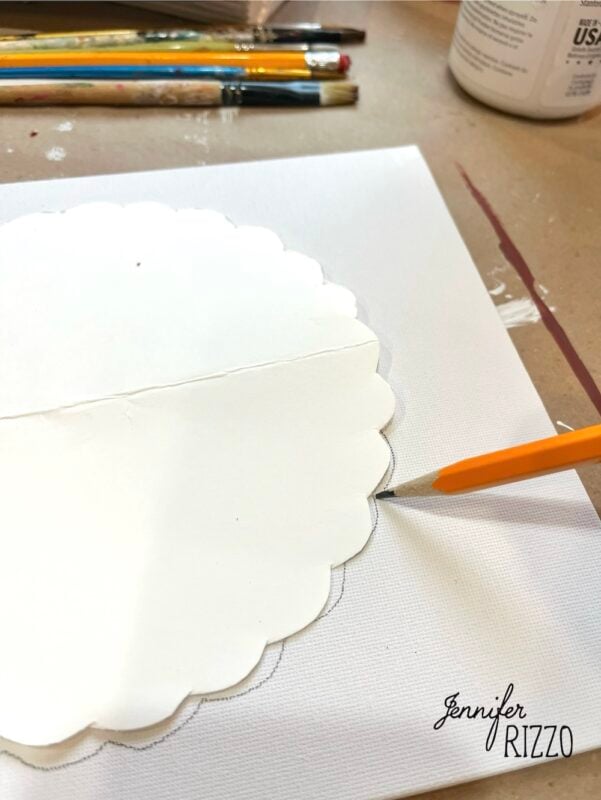 A pencil traces around a scalloped paper template on a white canvas, hinting at Pumpkin Pie Wall Art in progress, with paintbrushes and a container nearby; Jennifer Rizzo's logo appears in the corner.