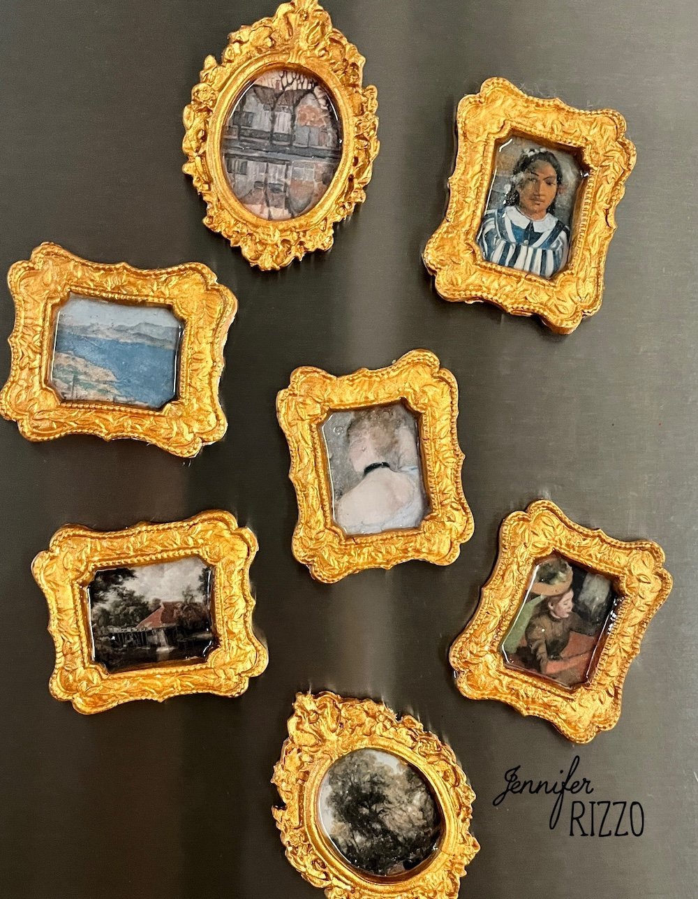 Seven small, ornate gold-framed art prints are displayed on a dark surface in a loose arrangement. The name "Jennifer Rizzo" appears in the lower right corner.