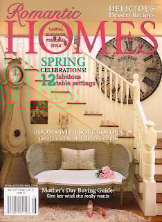 Cover of Romantic Homes magazine featuring a living room with a staircase, a large wall clock, and a couch with patterned pillows. Includes tips from About Jennifer Rizzo, plus spring table settings and a Mother's Day guide.
