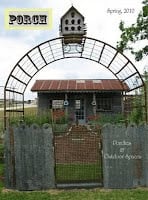 A rustic metal gate and arch welcome you to a small house with a tin roof, garden beds, and a large birdhouse above the entrance. Text reads "PORCH" and "Porches & Outdoor Spaces." Learn more in About Jennifer Rizzo.