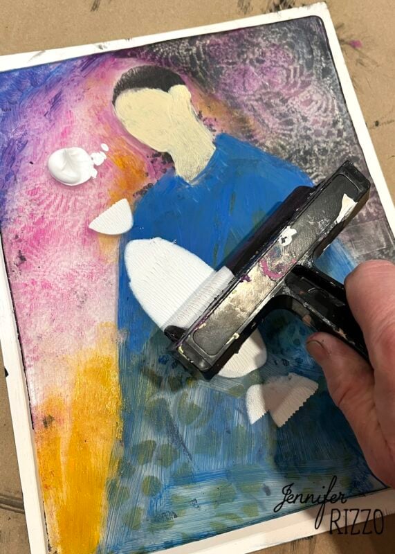 A hand uses a brayer to apply white paint onto an abstract portrait painting with a colorful background. The artist's signature "Jennifer Rizzo" is visible in the bottom right corner.
