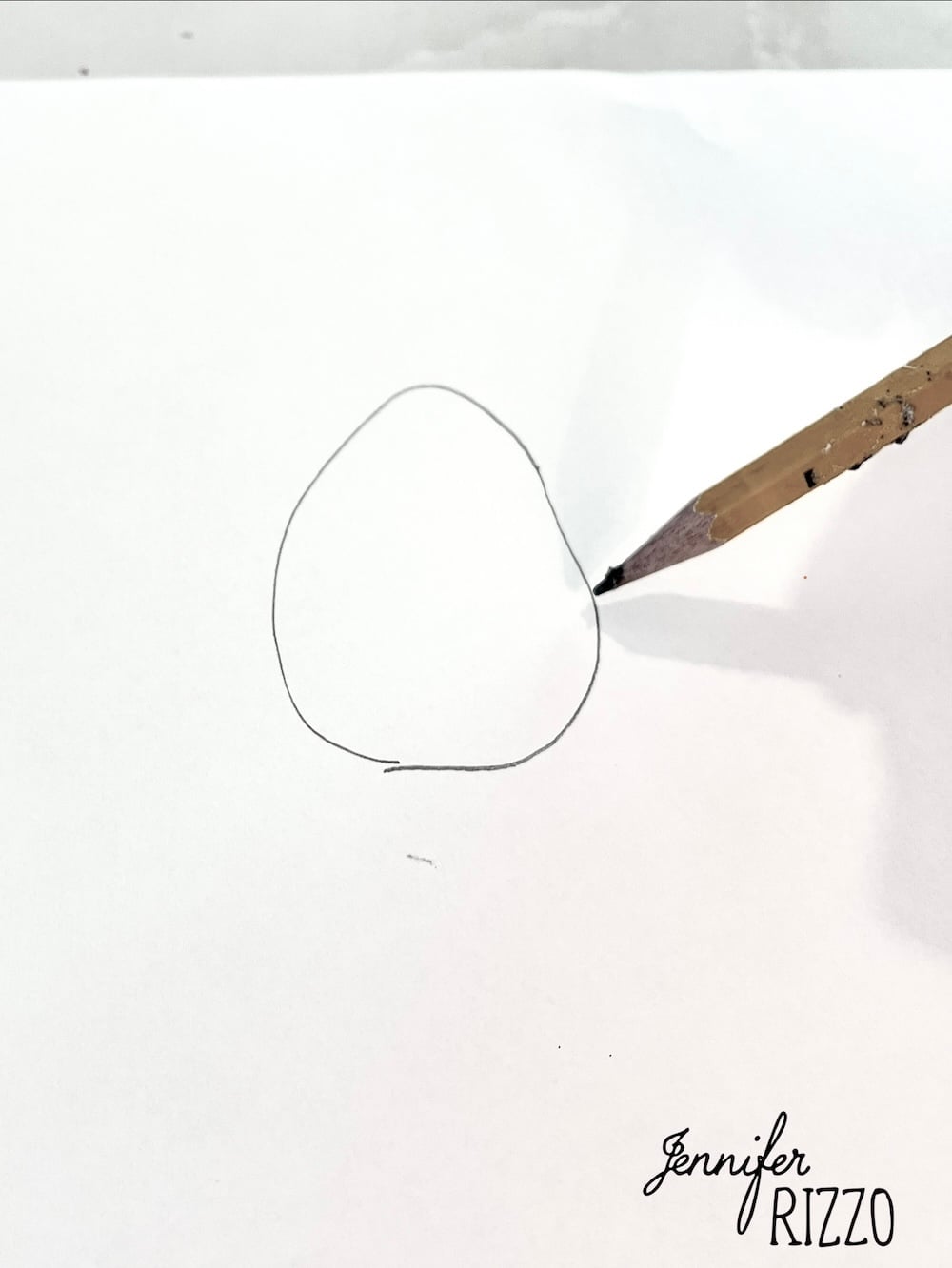 A pencil is drawing an uneven circle on a white sheet of paper. "Jennifer Rizzo" is written in cursive in the bottom right corner.