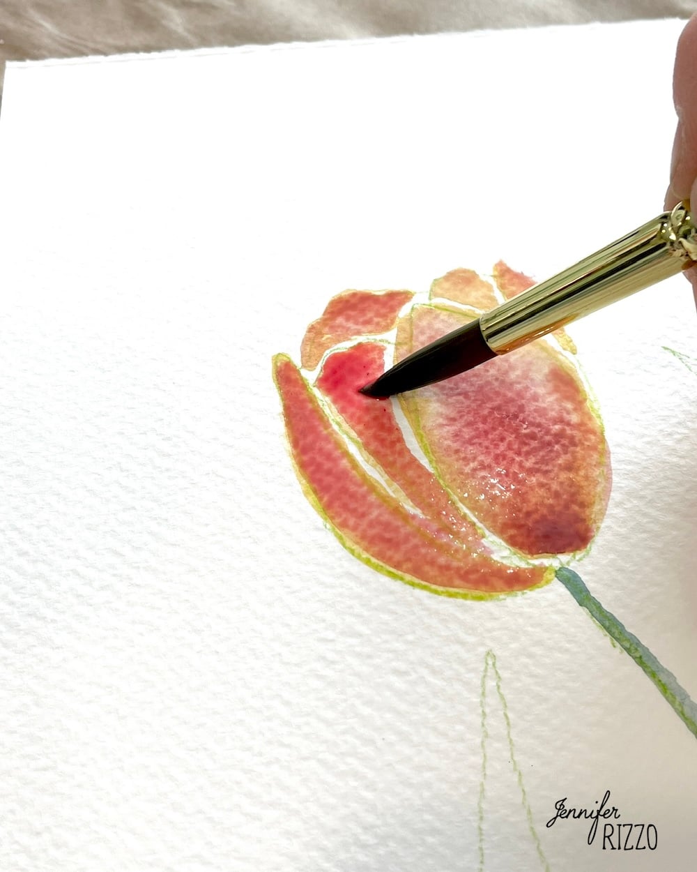 A close-up of a paintbrush applying red watercolor to a tulip flower on textured white paper, with "Jennifer Rizzo" signed in the corner.
