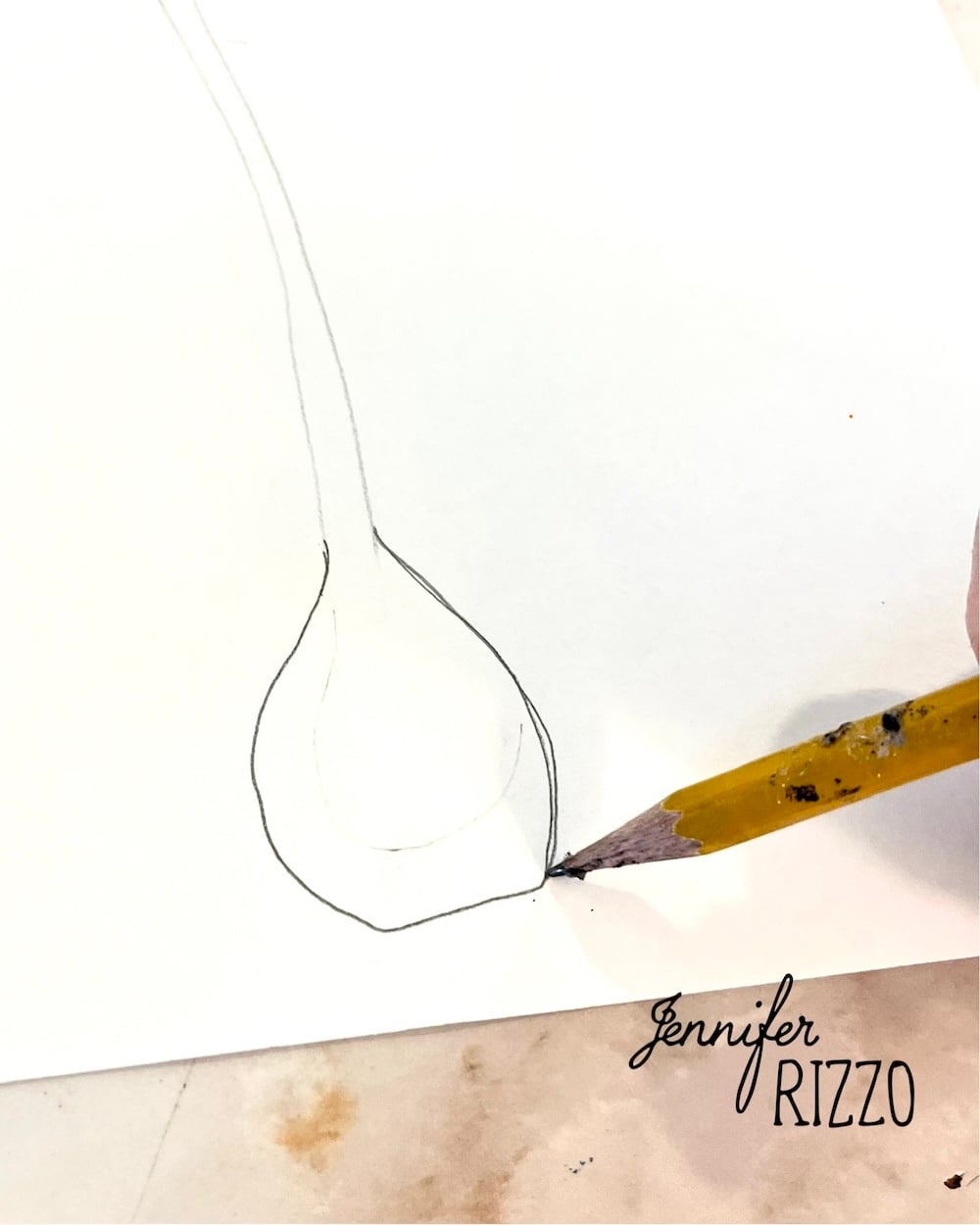 A hand uses a pencil to outline the shape of a bulb on white paper. The name "Jennifer Rizzo" is printed in the lower right corner.