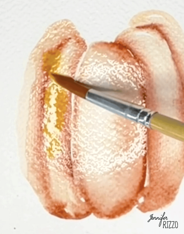 A paintbrush applies yellow watercolor to a brown and orange pumpkin painting on textured white paper. The name “Jennifer Rizzo” is written in the bottom right corner.