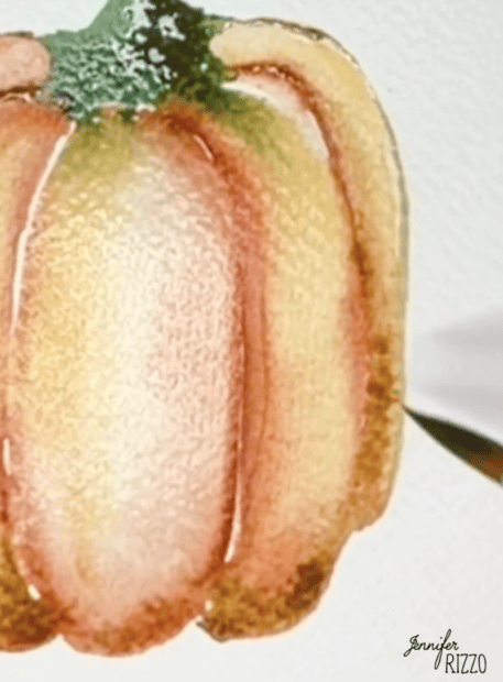 Watercolor painting of an orange pumpkin being outlined with a paintbrush on textured paper; the artist’s signature, Jennifer Rizzo, is visible.