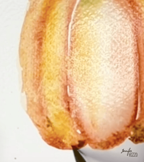 Watercolor painting of a pumpkin in shades of orange and yellow on white paper, with a paintbrush tip visible at the bottom.