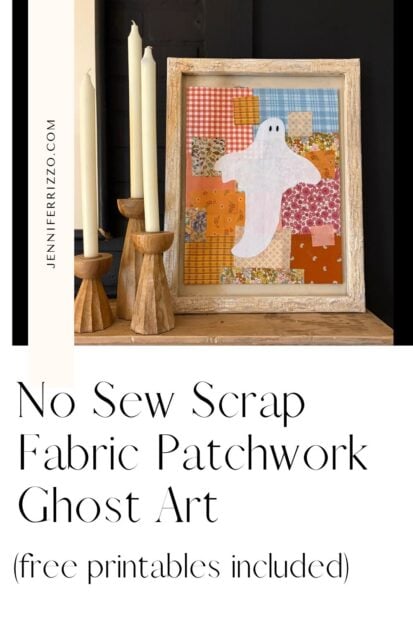 Framed patchwork fabric art with a white ghost, displayed on a wooden surface beside three tall white candles in wooden holders.
