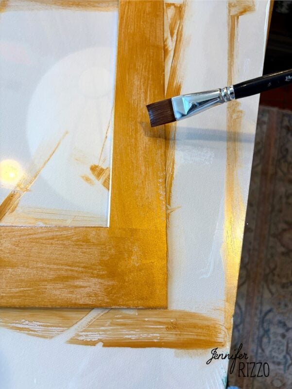 A paintbrush applies gold paint to the edge of a white canvas. The name “Jennifer Rizzo” appears in the bottom right corner.
